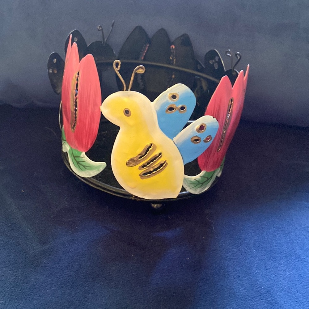 Metal candle holder, happy looking, whimsical design.